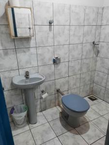 a bathroom with a blue toilet and a sink at HOTEL TROPICAL in Cuiabá