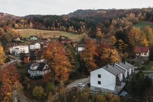a small town in the mountains with a white house at CZARNA OWCA Apartament - SKRZYCZNE Residence in Szczyrk