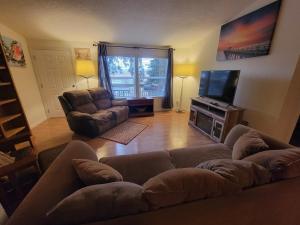 a living room with a couch and a television at Crater Lake Gateway-Rocky Point Resort in Klamath Falls