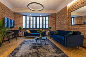Galeria Italiana Apartments في فروتسواف: غرفة معيشة مع أريكة زرقاء وطاولة