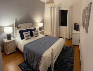 a bedroom with a large bed with blue pillows at Madalena Sunset by Madeira Sun Travel in Madalena do Mar