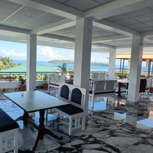 a patio with tables and chairs and a view of the ocean at Blue Bridge Homes in Port Blair