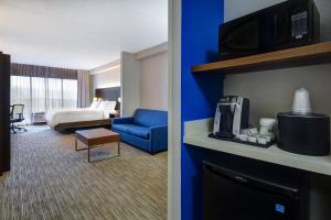 Habitación de hotel con pared de color azul y sala de estar. en Holiday Inn Express Hotel & Suites Smyrna-Nashville Area, an IHG Hotel en Smyrna