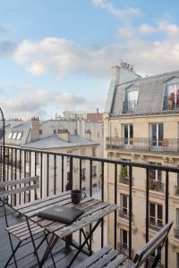 - une table et des chaises sur un balcon avec des bâtiments dans l'établissement Hotel Saint-Louis Pigalle, à Paris