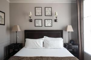 a bedroom with a bed with three pictures on the wall at Hotel Saint-Louis Pigalle in Paris