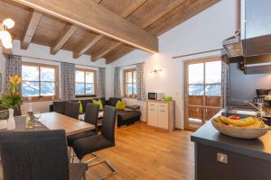 a kitchen and living room with a table and a couch at Ferienwohnungen Egg in Fieberbrunn