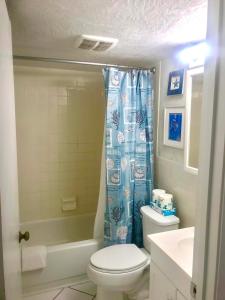 a bathroom with a toilet and a shower curtain at Coastal Sands - Ocean View at Symphony Beach Club! in Ormond Beach