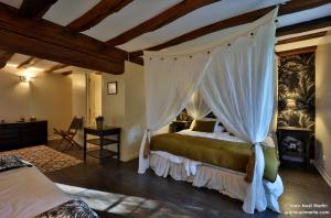 ein Schlafzimmer mit einem Himmelbett in der Unterkunft Le Domaine de Moroges in Moroges