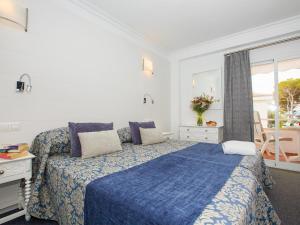 a bedroom with a blue bed and a window at Hotel Villa Singala in Port de Pollensa