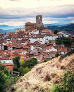 a town on a hill with a clock tower at La casita del olivo in Hervás