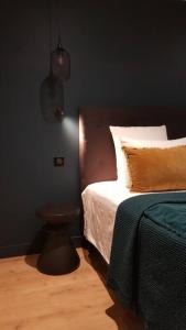 een slaapkamer met een bed en een lamp aan de muur bij La Maison de l'Ecu : charme et vue incroyable in Beaune