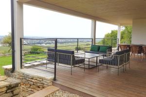 een veranda met stoelen en een tafel op een balkon bij La Maison de l'Ecu : charme et vue incroyable in Beaune