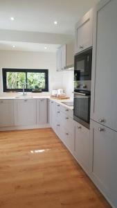 eine Küche mit weißen Schränken und Holzböden in der Unterkunft La Maison de l'Ecu : charme et vue incroyable in Beaune