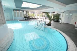 a large swimming pool in a large building at 25h SPA-Residenz POOLs IN & OUT, private Garden & Beach in Neusiedl am See