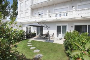 uma casa branca com um pátio e um relvado em 25h SPA-Residenz POOLs IN & OUT, private Garden & Beach em Neusiedl am See