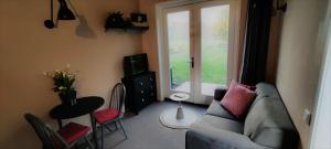 a living room with a couch and a window at Halte Liempde Logies in Liempde