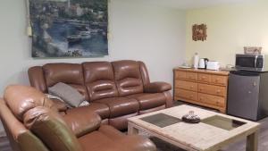 a living room with a brown leather couch and a coffee table at Sacred Pilgrimage Studio in Metchosin