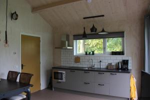 a kitchen with a sink and a window at Halte Liempde Logies in Liempde