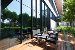 a group of tables and chairs on a deck with windows at Metropolis Hotel in Bistriţa