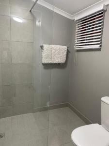 a bathroom with a glass shower with a toilet at Rest at Lieben in Bloemfontein