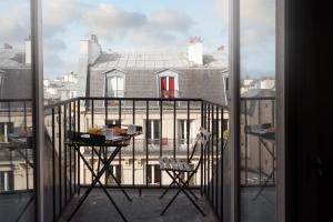 a balcony with a table and a view of a building at Hôtel Avama Montmartre in Paris