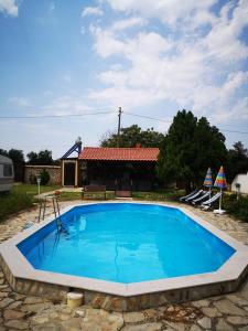 a large blue swimming pool in front of a house at Camping Little Oasis in Ezerets
