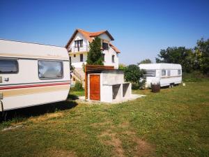 zwei Wohnwagen in einem Hof neben einem Haus in der Unterkunft Camping Malkiq oazis in Ezerets