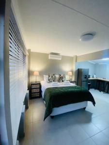 a bedroom with a large bed and a kitchen at Rest at Lieben in Bloemfontein