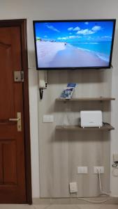 a flat screen tv hanging on a wall with a television on it at FLOR DE PASCUA in Acantilado de los Gigantes