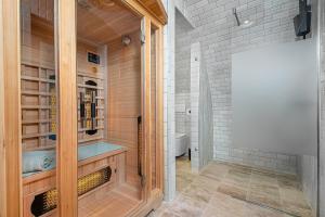 a bathroom with a walk in shower with a glass door at Gejzír Vendégház in Tihany
