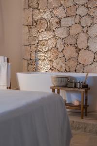 a stone wall in a bathroom with a table at Casas de San Pedro in Hita
