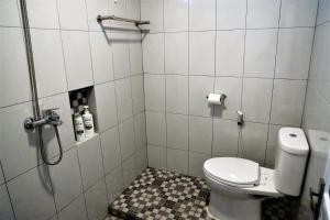 a small bathroom with a toilet and a shower at Grace Wave Resort in Hilibotodane