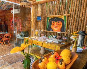 a room with a table with a painting of a woman at Pousada Quinta da Lagoa Azul in Jijoca de Jericoacoara
