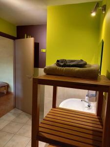 een badkamer met een wastafel en een groene muur bij Aux Saveurs d'Enneille in Durbuy
