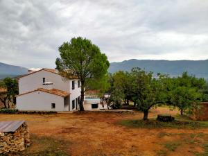 una casa blanca con árboles delante de ella en Más del Sandungo en Els Ibarsos