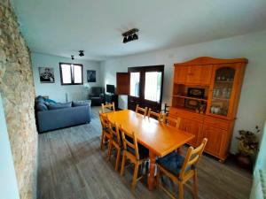 comedor y sala de estar con mesa y sillas en Más del Sandungo en Els Ibarsos