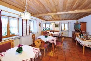 a restaurant with tables and chairs and windows at Haus Vogl in Berchtesgaden