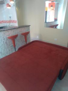 ein rotes Bett in einem Zimmer mit Spiegel in der Unterkunft Vista em Frente ao Mar em Guilhermina in Praia Grande