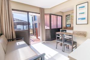 a kitchen and living room with a table and chairs at Flat Pietra in Florianópolis