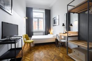 Habitación con cama, escritorio y TV. en NOVUMHOUSE - Straszewskiego, en Cracovia