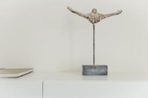 una statua di metallo su un tavolo con un libro di Trendy Apartments as Base to Discover Ghent a Gand