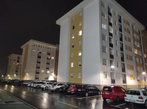 a large white building with cars parked in a parking lot at S&S Apartman Banja Luka in Banja Luka