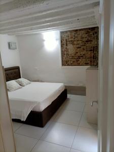 ein Schlafzimmer mit einem Bett und einer Ziegelwand in der Unterkunft Blusuite appartamento in Venedig