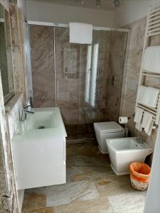 a white bathroom with a sink and a toilet at Blusuite appartamento in Venice