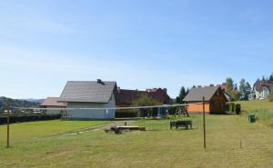 a group of houses with a playground in a field at Domki Pod Lasem in Polańczyk