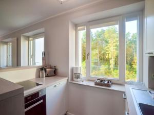 eine Küche mit zwei Fenstern, einem Waschbecken und einer Theke in der Unterkunft Dünenresidenz Prora - Ferienwohnung mit Meerblick, 1 Schlafzimmer und Balkon NP-312 in Binz
