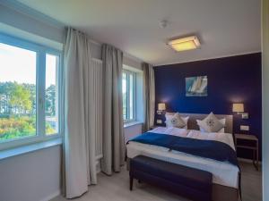 ein Schlafzimmer mit einem Bett und einem großen Fenster in der Unterkunft Dünenresidenz Prora - Ferienwohnung mit Meerblick, 1 Schlafzimmer und Balkon NP-312 in Binz