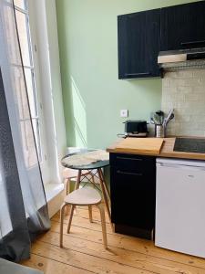 a kitchen with a table and a small table at LE DUMON 3 - Studio NEUF LUMINEUX - Balcon - WiFi - Gare 200m in Agen