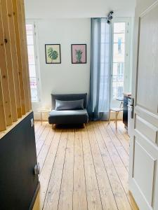 a living room with a couch and a wooden floor at LE DUMON 3 - Studio NEUF LUMINEUX - Balcon - WiFi - Gare 200m in Agen