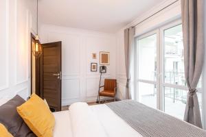 Un dormitorio blanco con una cama y una ventana. en Super-Apartamenty Andersia VIP II, en Poznan